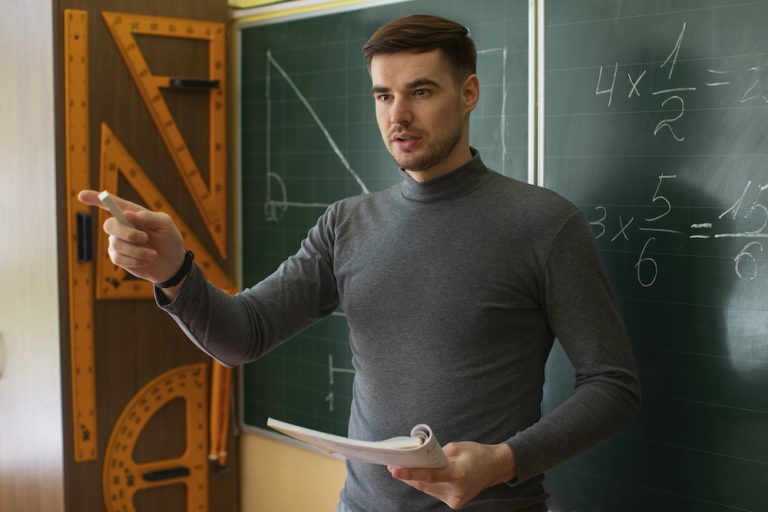 Un jeune professeur de mathématiques fait cours à ses élèves