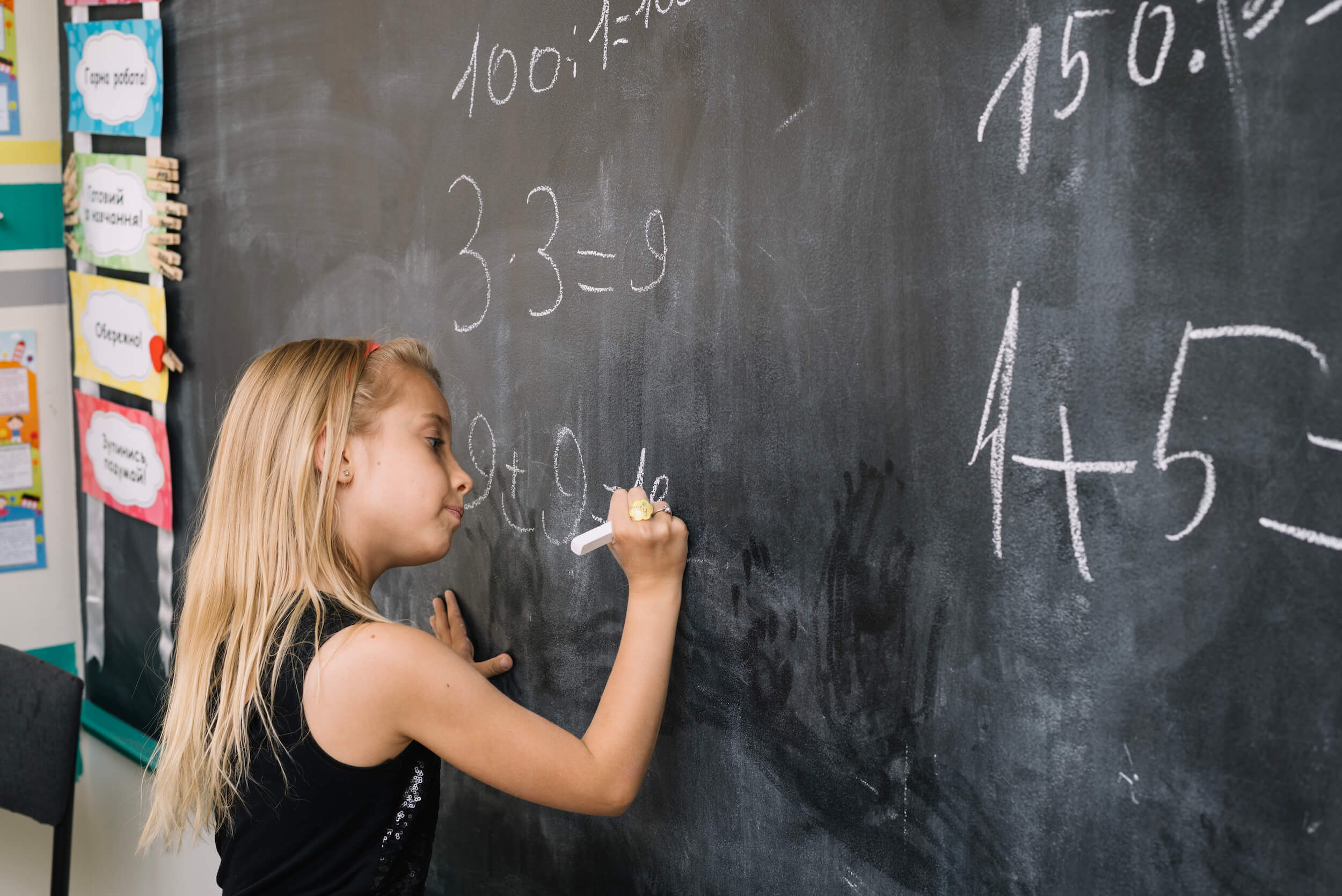 Une élève résout des problèmes mathématiques au tableau