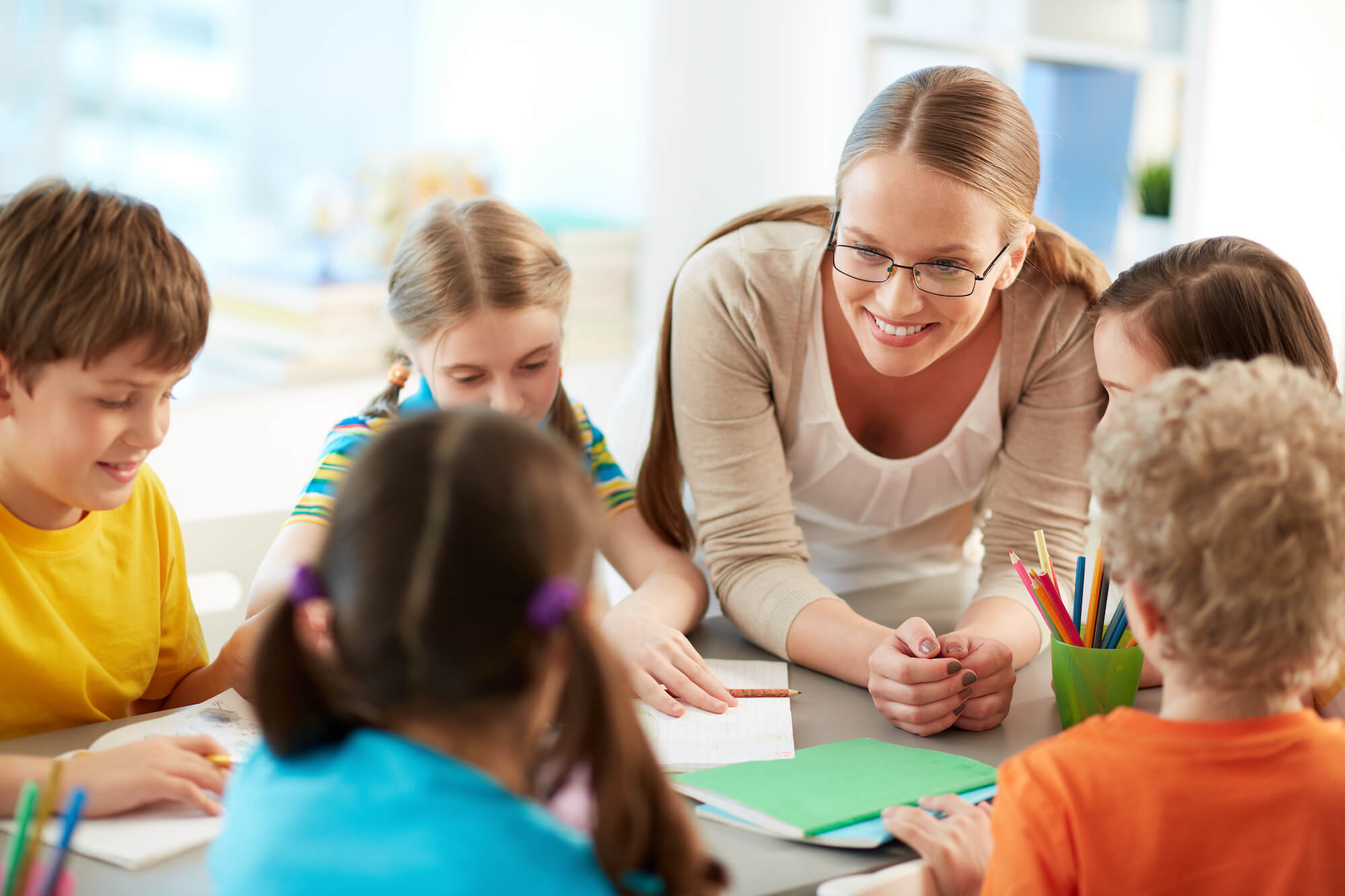 Une enseignante de primaire entourée de ses élèves